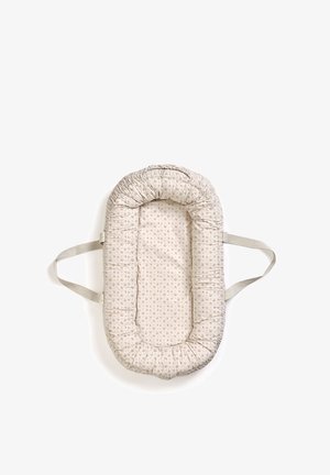 Blød, oval baby-liggeplads med lille blomstermønster og to beige sidehåndtag på hvid baggrund.