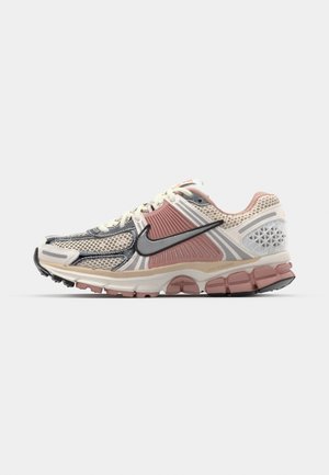 Nike-Laufschuhe mit einem Obermaterial aus Mesh in Beige und Pink, strukturierten Überzügen, schwarzem Akzent-Swoosh und einer gepolsterten Sohle mit einem pinken Abschnitt.
