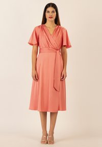 Korallenfarbenes Wickelkleid mit kurzen, schwingenden Ärmeln und einem Taillengürtel. Hergestellt aus glattem Stoff, weist es einen V-Ausschnitt und einen mittellangen Saum auf.