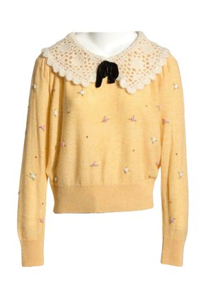 Pull jaune à manches longues avec petites fleurs brodées roses et blanches, grand col en dentelle blanche et nœud en velours noir à l'encolure.