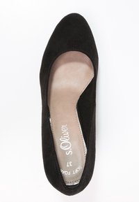 Black suede pump with a rounded toe, soft beige insole, and minimalistic design. Features subtle stitching and a low-cut vamp.