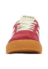 Sneaker rossa in suede con strisce bianche in pelle, lacci beige e suola in gomma testurizzata color gomma. Presenta un logo sulla linguetta.