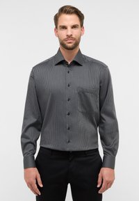 Zwart-wit gestreepte lange mouwen shirt met een button-down kraag, een borstzak en zwarte knopen. Gladde stof met een gestructureerde pasvorm.