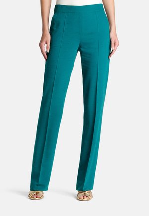 Teal, wide-leg trousers made of smooth fabric with a flat waistband and two vertical front seams for detailing. Gold sandals are partially visible.