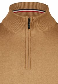 Beiger Zip-Up-Pullover aus weichem Strickstoff. Verfügt über einen gerippten Kragen mit einem kontrastierenden gestreiften Muster in Rot, Weiß und Blau.