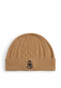 Braune gestrickte Mütze mit einem Zopfmuster und einem gerippten Bündchen. Mit einem schwarzen gestickten Logo auf der Vorderseite. Weicher Stoff.