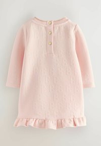 Helles rosa Kleid mit langen Ärmeln, das ein strukturiertes Muster von "B"-Buchstaben aufweist, einen runden Ausschnitt, einen Knopfverschluss auf der Rückseite und einen gerüschten Saum hat.
