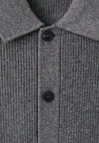 Szary prążkowany kardigan dziany z kołnierzykiem i czarnymi guzikami. Tkanina ma miękką fakturę z subtelnymi odcieniami.