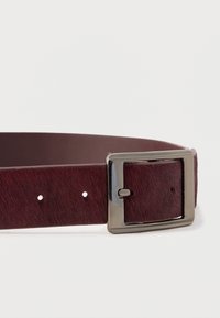 Burgunderfarbener Ledergürtel mit glatter Oberfläche und dezentem Muster, ausgestattet mit einer silberfarbigen rechteckigen Schnalle und fünf Einstelllöchern.