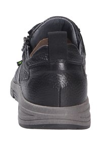 Scarpa in pelle nera con finitura testurizzata, forma arrotondata e interno imbottito. Presenta un tassello sul retro e una suola grigio resistente.