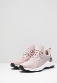 Baskets de sport rose clair en tissu en maille. Comprend des lacets, un talon rembourré, une semelle extérieure en caoutchouc noir et des détails perforés pour la respirabilité.