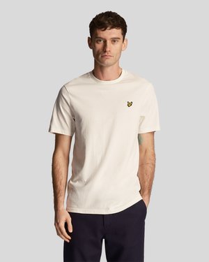 Crème katoenen t-shirt met een ronde hals en korte mouwen; heeft een klein geel vlinderlogo op de borst.