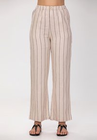 Pantalons larges beige clair à rayures verticales bleu marine, fabriqués en tissu respirant. Dotés d'une taille élastique et de quincaillerie minimale.