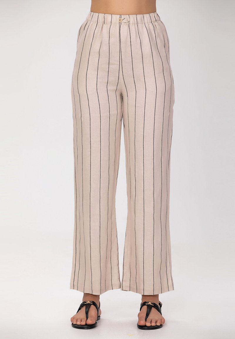 Pantalons larges beige clair à rayures verticales bleu marine, fabriqués en tissu respirant. Dotés d'une taille élastique et de quincaillerie minimale.