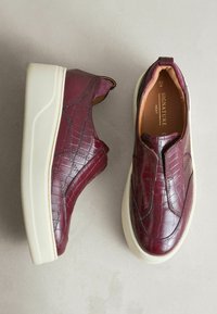 Bordeaux slip-on shoes med et tekstureret, prægnet krokodillemønster, der har en tyk hvid sål og elastiske sidepaneler for nem påtagning.
