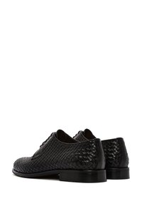 Chaussures en cuir noir avec texture tissée, bout rond et talon bas empilé. Dotées d'un système de laçage et d'une finition lisse, conçues pour les occasions formelles.