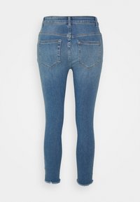 Jeans azuis slim-fit feitos de denim, com uma cintura alta, design de cinco bolsos e bainha desgastada nos tornozelos. Vista traseira mostrada.