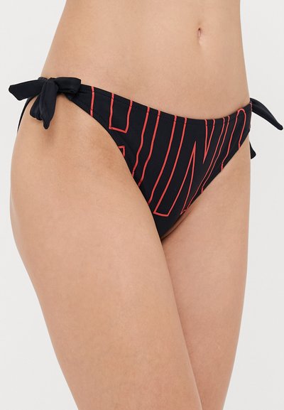 Melna bifida bikini apakša ar sarkanu svītru rakstu un sānu saitēm. Audums izskatās gluds ar nelielu spīdumu. Minimālistisks dizains ar regulējamiem elementiem.