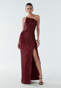 Merlot red sequined evening gown with a fitted silhouette, one-shoulder design, side slit, and ankle-length hem. Smooth fabric texture.