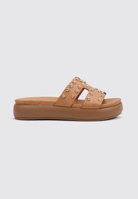 Sandalias deslizantes marrones con una parte superior de cuero suave, que presentan tachuelas doradas decorativas y una suela de plataforma para mayor altura y comodidad.