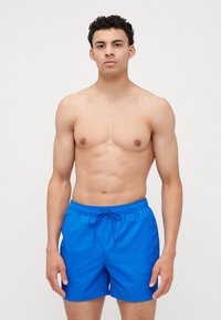Blauwe zwembroek met een elastische tailleband en drawstring. Lichtgewicht materiaal, rechte snit en een gladde textuur. Geschikt voor wateractiviteiten.