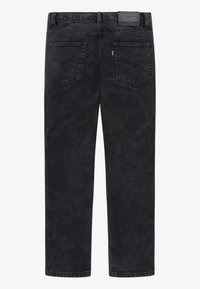 Jeans in denim nero con una morbida texture, design a cinque tasche e cuciture visibili. Presentano un'etichetta con logo sulla vita.