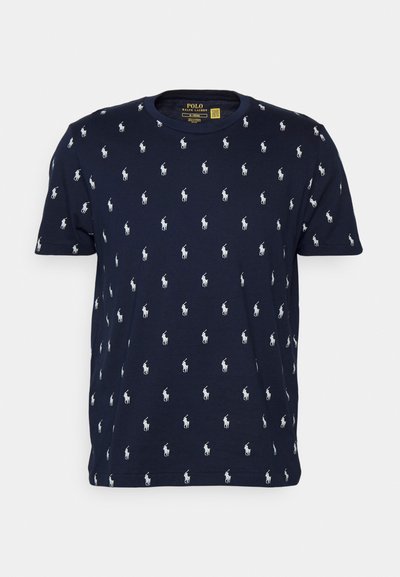 Tricou din bumbac de culoare bleumarin, cu guler rotund și model alb cu jucători de polo pe întreaga suprafață. Mâneci scurte cu tiv drept.