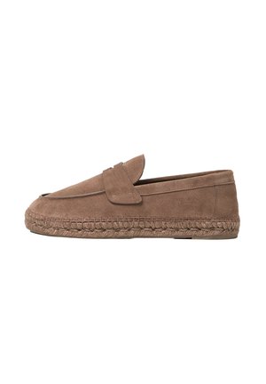 Mocassin en daim marron avec une semelle intermédiaire en jute tressée et un détail de bride, avec un marquage subtil sur le côté.