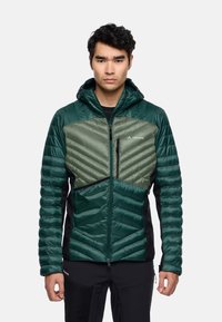 Grüne Jacke mit Kapuze, die ein dreieckiges Steppmuster und kontrastierende dunkle Akzente aufweist. Das Material scheint glänzend zu sein und hat eine strukturierte Passform.