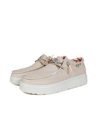 Scarpe in tela beige con design arrotondato, suola in gomma bianca e cuciture decorative. L'interno presenta un motivo a righe in colori vivaci.