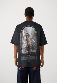 Sort t-shirt med et stort rygtrykt motiv af Gustave Moreaus "Sankt George og dragen," med tekst i hvid og rød.