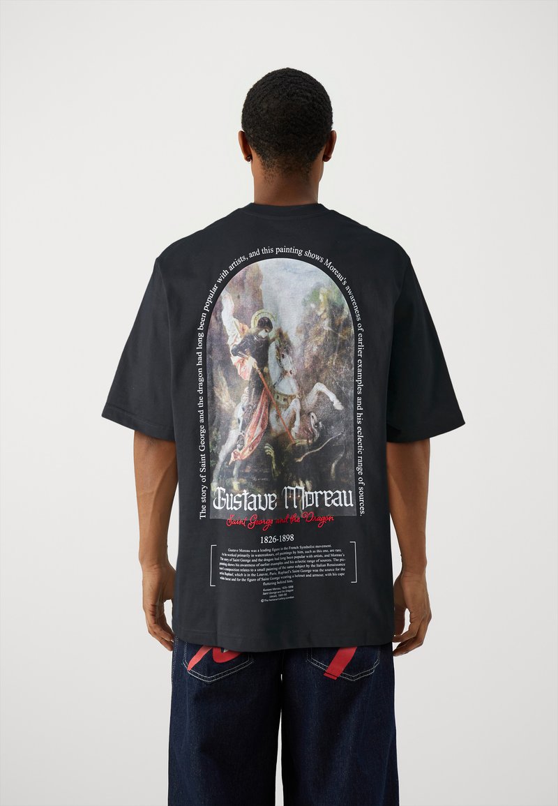 Zwart t-shirt met een grote achterprint van Gustave Moreau's "Sint Joris en de Draak," met tekst in wit en rood.