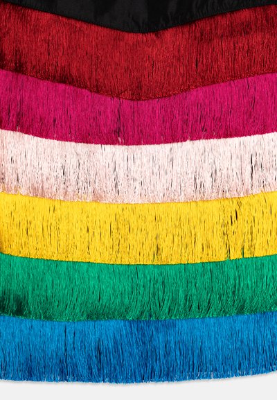 Franges disposées en sept rangées horizontales : rouge, fuchsia, rose clair, jaune, vert et bleu. Chaque frange est brillante avec un aspect texturé et superposé.