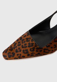 Spisse tå sko i brun dyreprint med myk tekstur, svarte accenter og slip-on design.