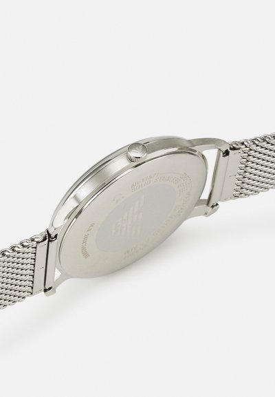 Edelstahlarmbanduhr mit einem polierten runden Gehäuse, einem strukturierten Mesh-Armband und einer seitlichen Krone. Eingravierte Details auf der Rückseite sind sichtbar.