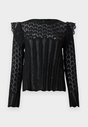 Blouse noire à manches longues en dentelle avec des motifs géométriques et floraux, détails froncés aux épaules, et ourlet et poignets à bords festonnés.