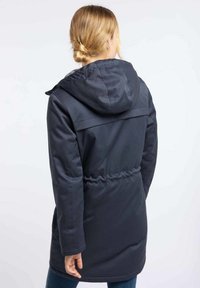 Parka de color azul marino oscuro con cintura ajustada, capucha y textura suave, que presenta un corte recto y un diseño minimalista.
