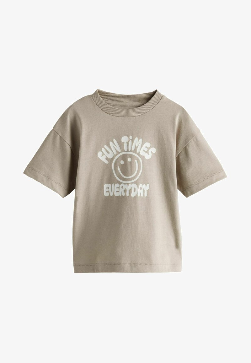 Brūns kokvilnas T-krekls ar īsām piedurknēm, uz kura priekšpuses ir balti uzraksti "IZKLAIDES KATRAI DIENAI" un smaidoša sejas ilustrācija.