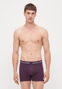 Lila Herren Boxershorts mit schwarzem Bund, der mit weißem Text "JACK & JONES" versehen ist. Glattes Material mit tailliertem Design.