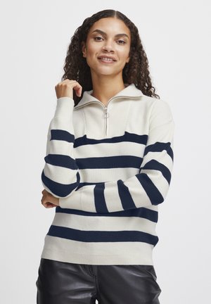 Pull crème avec des rayures horizontales bleu marine, col zippé, bord-côtes aux poignets et à l'ourlet. Texture tricotée douce, coupe décontractée et épaisseur moyenne.