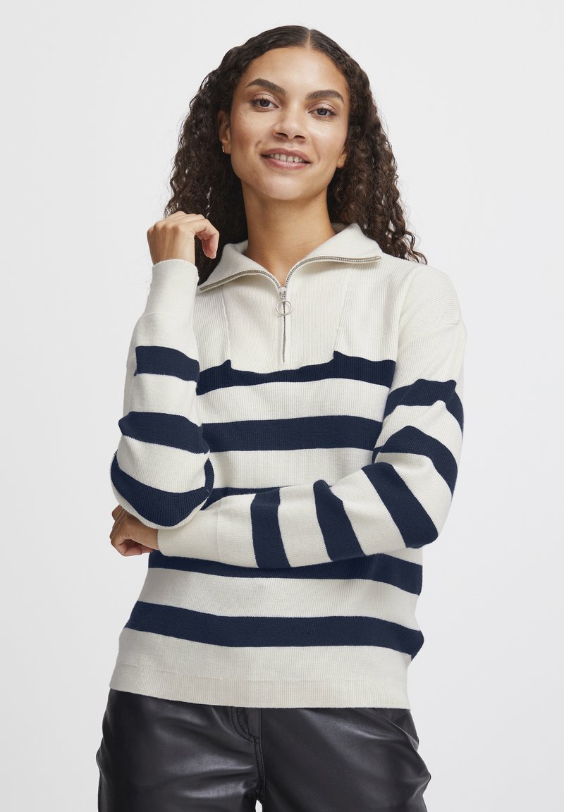 Pull crème avec des rayures horizontales bleu marine, col zippé, bord-côtes aux poignets et à l'ourlet. Texture tricotée douce, coupe décontractée et épaisseur moyenne.