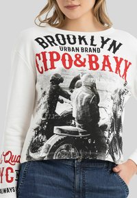 Weißes Sweatshirt mit einem schwarz-weißen Motorrad-Design und fettem roten Text "BROOKLYN CIPO&BAYX." Lockere Passform mit langen Ärmeln.