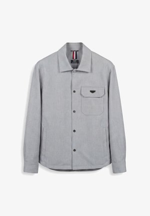 Camicia giacca grigio chiaro con colletto appuntito, taschino sul petto con patta, due tasche laterali e maniche lunghe.