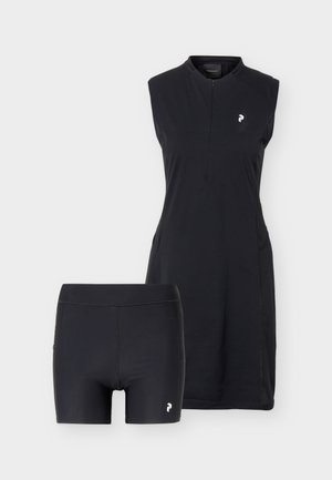 Abito sportivo nero senza maniche con zip a quarto e pantaloncini aderenti neri abbinati, entrambi con un piccolo logo bianco.