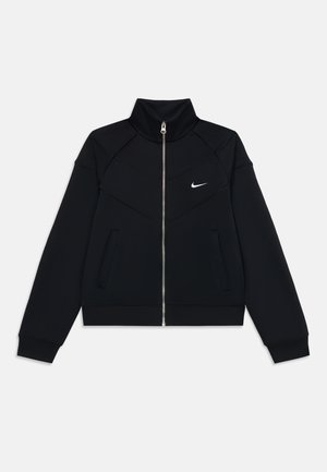 Veste noire Nike avec un col haut, une fermeture éclair à l'avant, deux poches latérales et un design texturé avec un logo blanc sur la partie gauche de la poitrine.