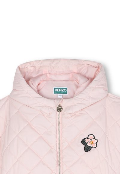Veste matelassée rose clair avec capuche, ornée d'un patch floral sur le côté gauche et d'une fermeture éclair avec un tirette décoratif.