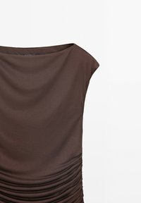 Robe marron sans manches avec un large décolleté, présentant du tissu froncé sur un côté, créant texture et mouvement. Matière lisse.