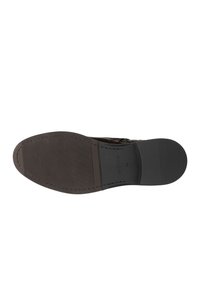 Onderzijde van een bruine nette schoen met een gestructureerde zool met parallelle groeven en maat 42 aangegeven op het middenstuk.