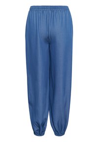 Pantalon bleu coupe ample avec ceinture élastique et bas élastiques aux chevilles, vu de dos.