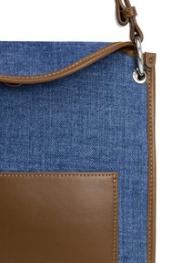 Denim válltáska barna bőr elülső résszel, barna kiegészítőkkel és ezüst hardware-rel. Puha tapintású és strukturált formájú.